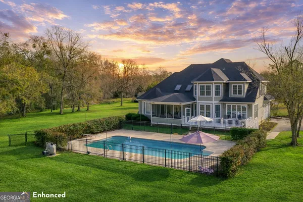 a view of a house with a big yard potted plants and large tree