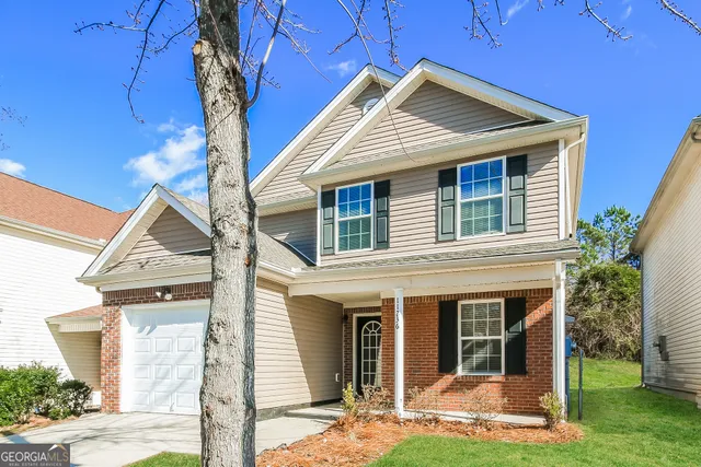 a view of a house with a small yard and wooden floor and fence
