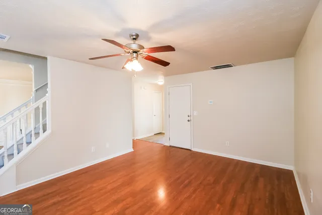 a view of an empty room with wooden floor