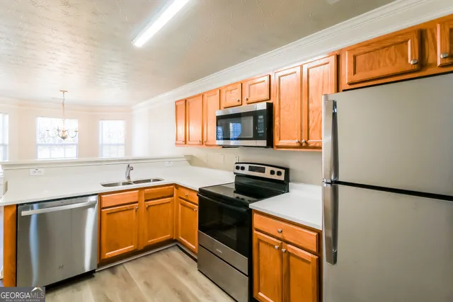 a kitchen with stainless steel appliances granite countertop a refrigerator a stove top oven a sink and dishwasher