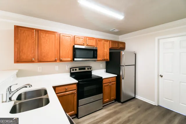 a kitchen with stainless steel appliances a stove a sink and a microwave