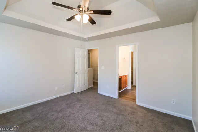 an empty room and chandelier fan