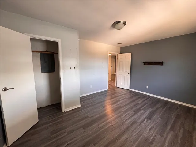 an empty room with wooden floor and closet