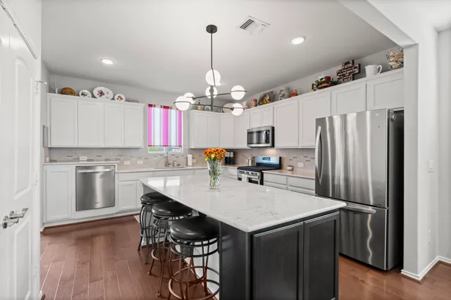 a kitchen with kitchen island a refrigerator stove microwave and cabinets