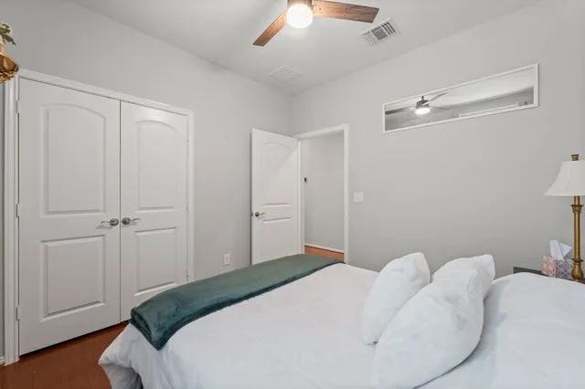 a bedroom with a bed and a ceiling fan