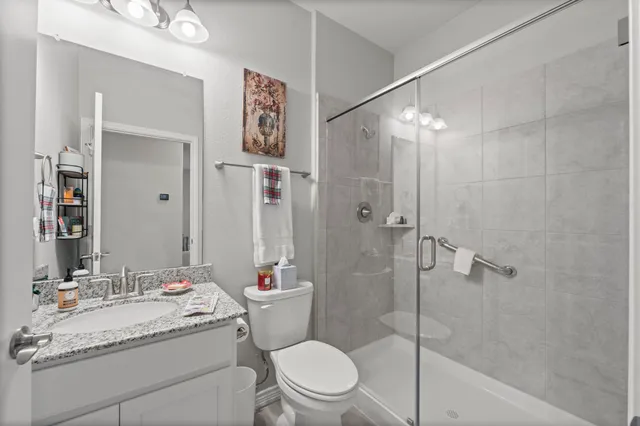a bathroom with a granite countertop sink toilet and shower