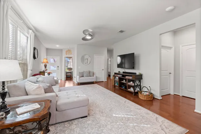a living room with furniture and a flat screen tv with wooden floor