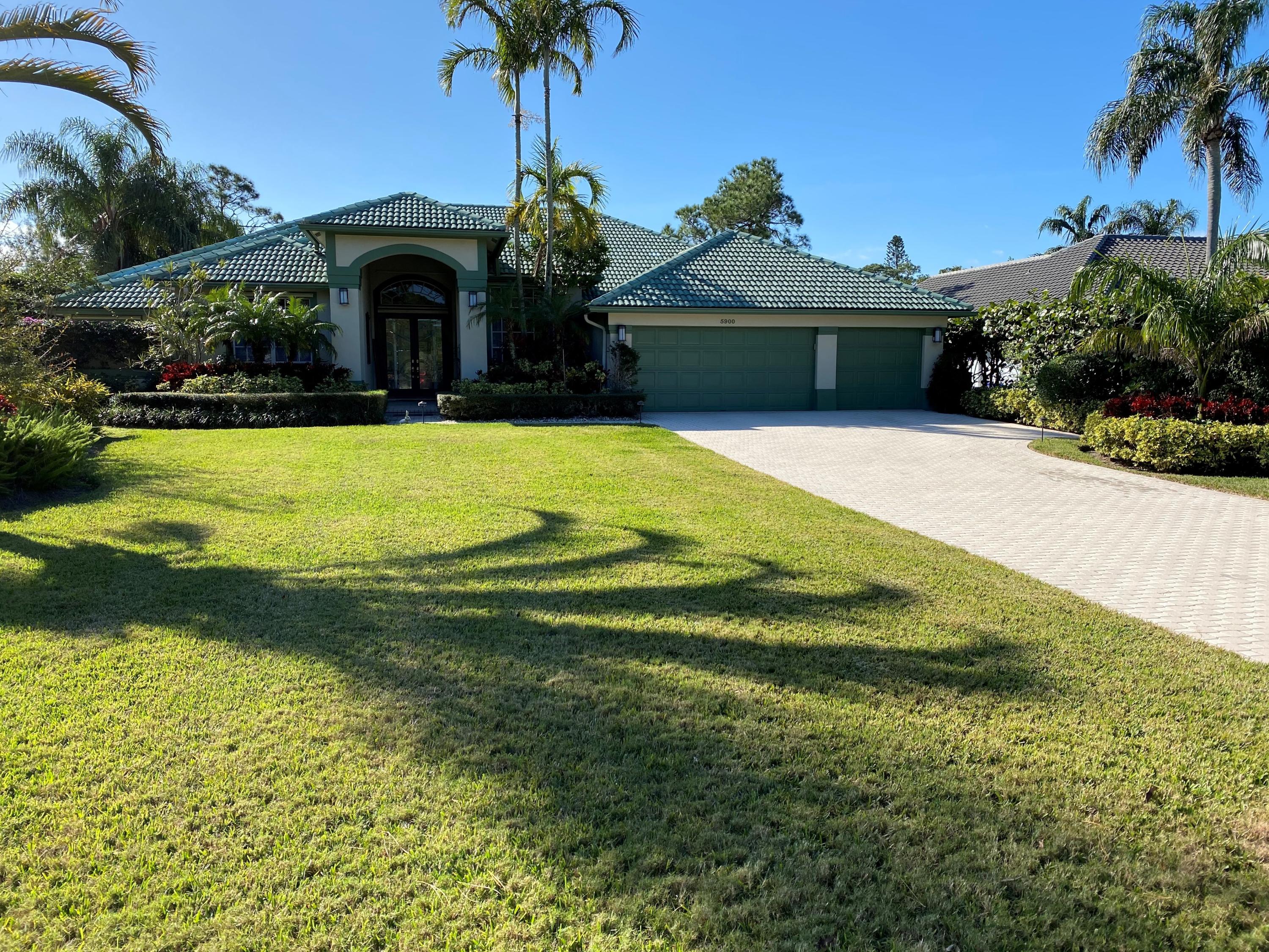 a front view of a house with a yard and potted plants