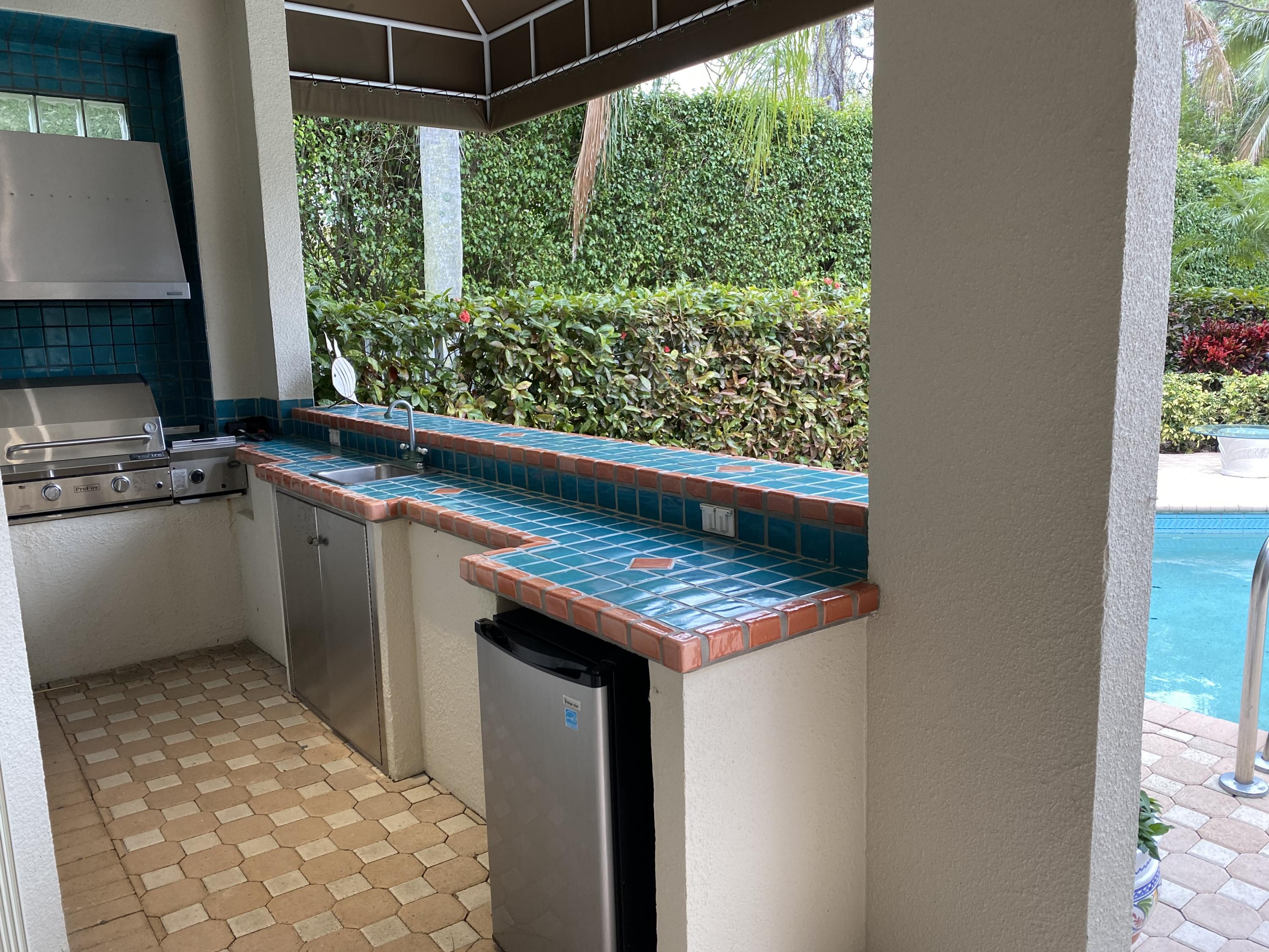 5900 Our Robbies Road Jupiter, FL 33458 - Photo 9 of 53 a view of a kitchen with a sink and wooden floor
