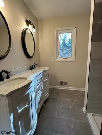 a bathroom with a double vanity sink and a mirror