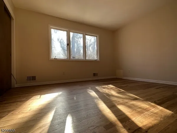 a view of a room with wooden floor and natural light