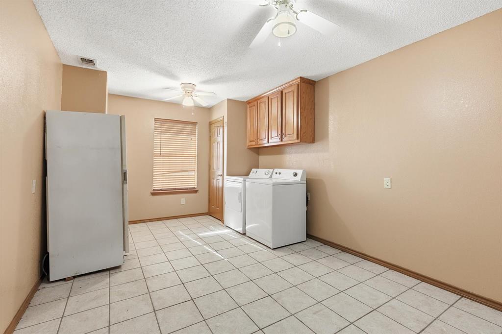 135 Private Road 2202 Decatur, TX 76234 - Photo 29 of 40 Laundry room featuring washing machine and dryer, a textured ceiling, ceiling fan, light tile patterned floors, and cabinet space