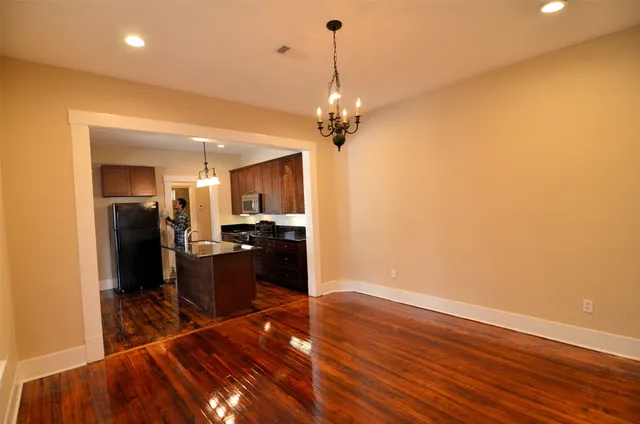a view of a kitchen with wooden floor and a refrigerator