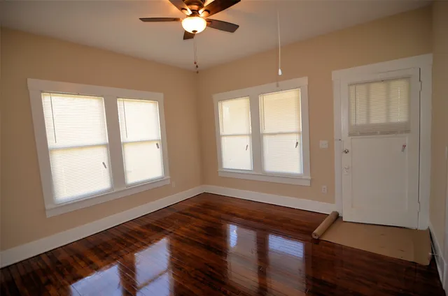 a room with chandelier fan and windows