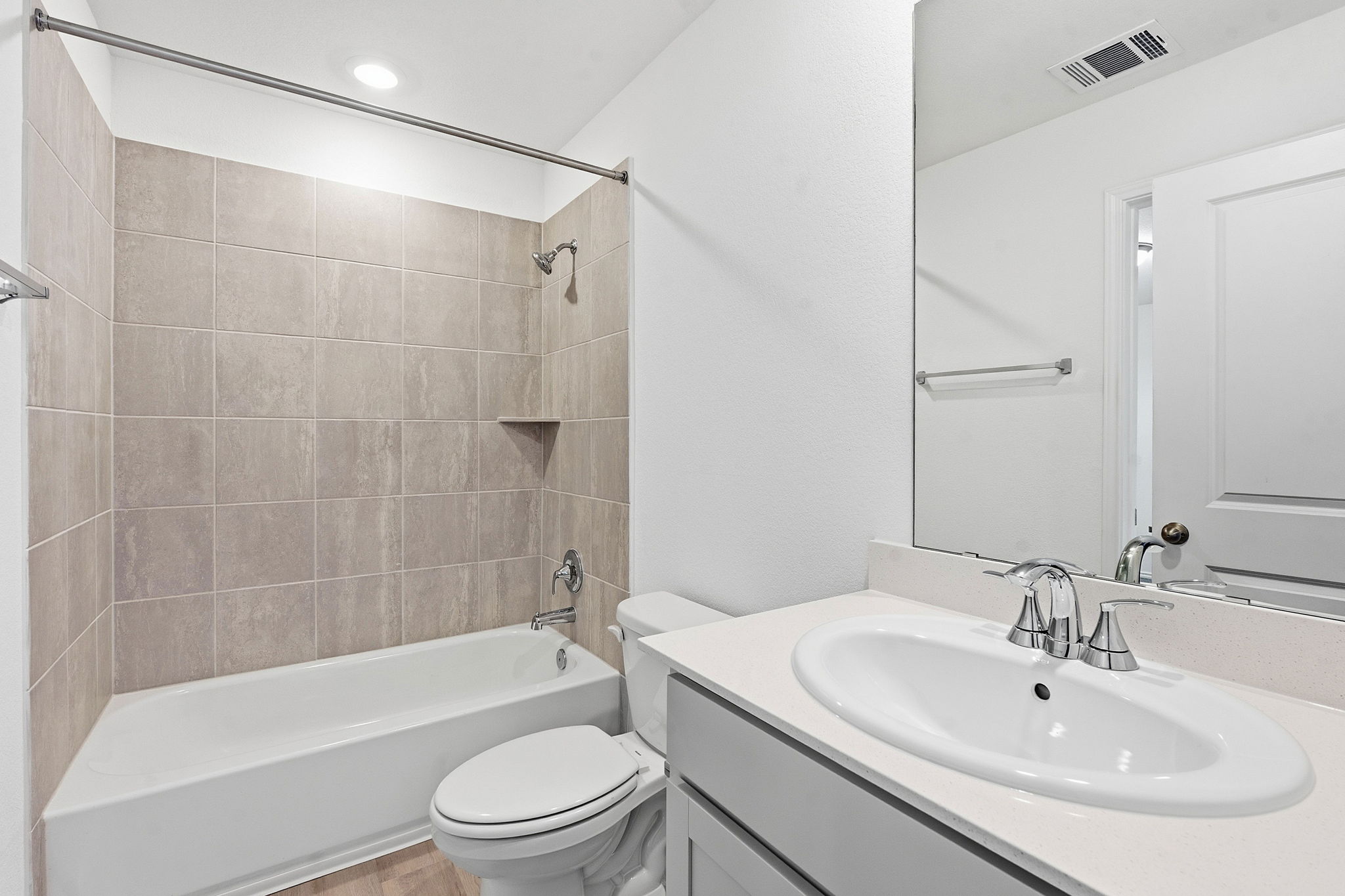 164 Cinnabar Lane, Unit 3 Kyle, TX 78640 - Photo 17 of 20 Bathroom featuring a white vanity with an undermount sink, a large mirror, and a tub-shower combination with light brown wall tiling and a built-in shelf