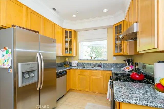 a kitchen with a sink a refrigerator and cabinets