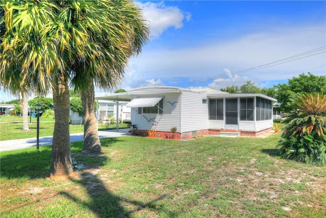 a view of a house with a yard and sitting area