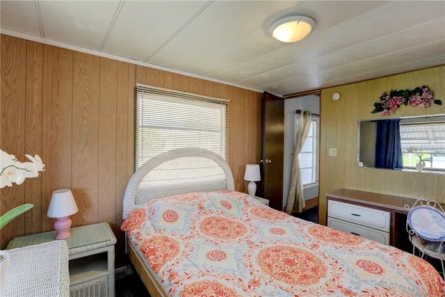 a bedroom with a bed and dresser with mirror