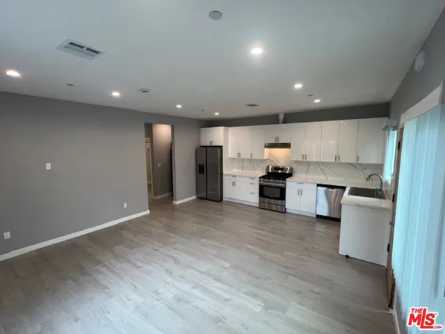 a view of a kitchen with a sink and a refrigerator