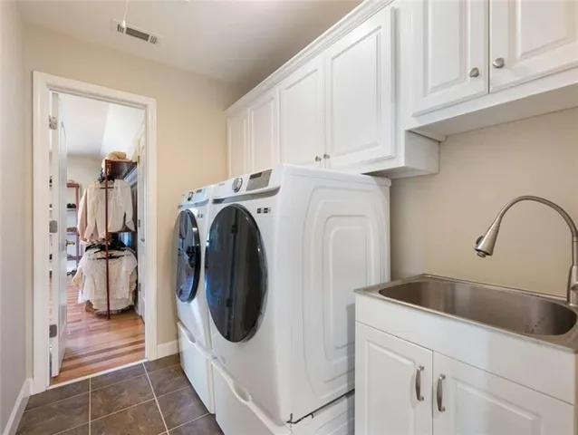 a utility room with sink dryer and washer