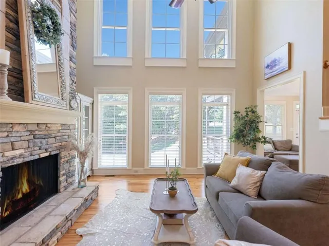 a living room with furniture a fireplace and a large window