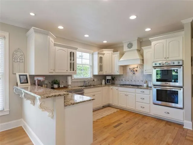 a kitchen with granite countertop white cabinets and white appliances