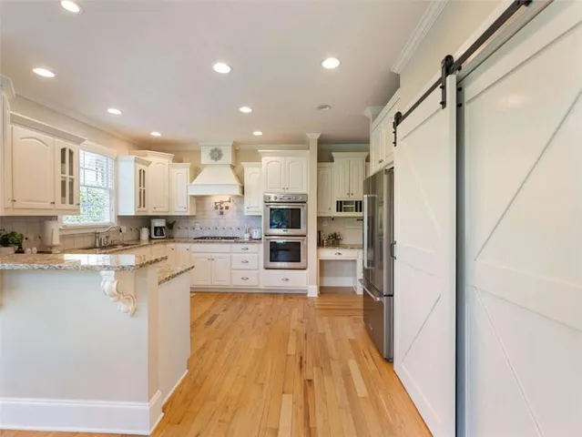 a large kitchen with a lot of counter space and a wooden floor