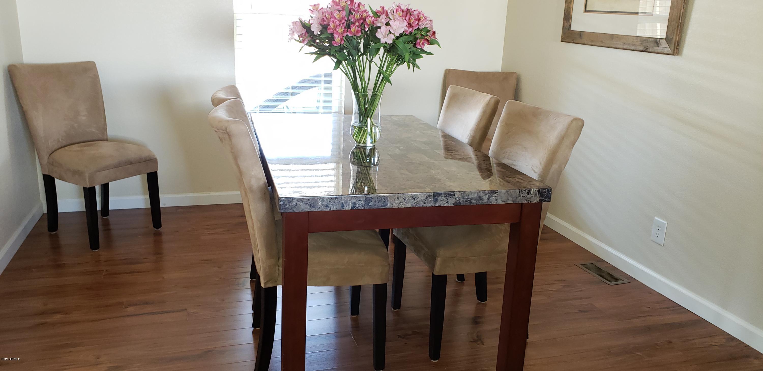 301 South Signal Butte Road, Unit 705 Apache Junction, AZ 85120 - Photo 12 of 50 a view of a dining room with furniture and wooden floor