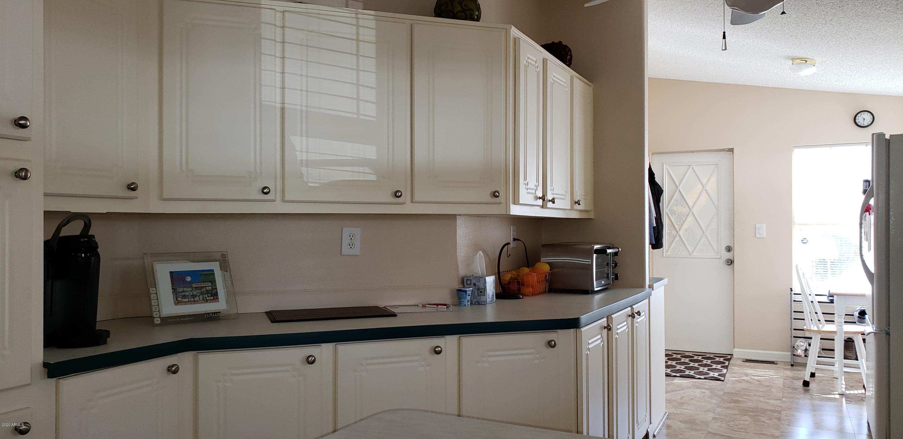 301 South Signal Butte Road, Unit 705 Apache Junction, AZ 85120 - Photo 15 of 50 a kitchen with stainless steel appliances granite countertop a sink a stove and white cabinets
