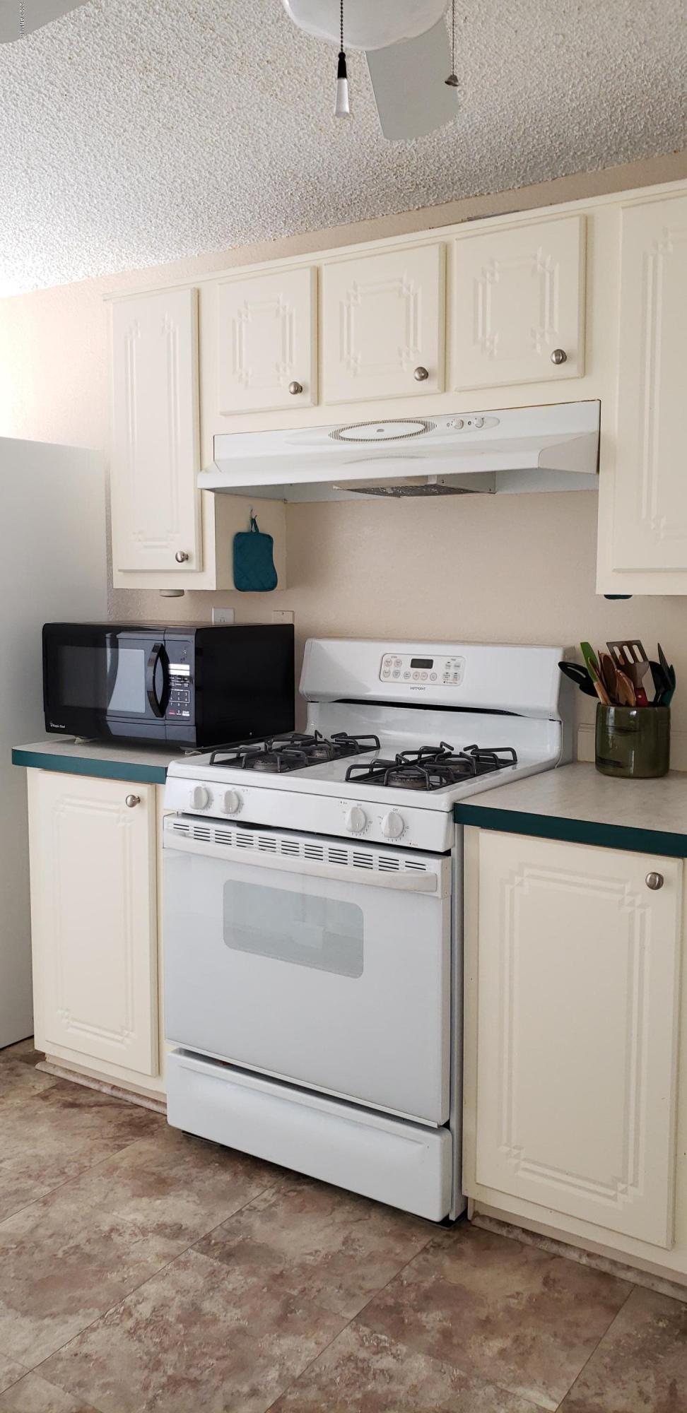301 South Signal Butte Road, Unit 705 Apache Junction, AZ 85120 - Photo 17 of 50 a kitchen with white cabinets and sink