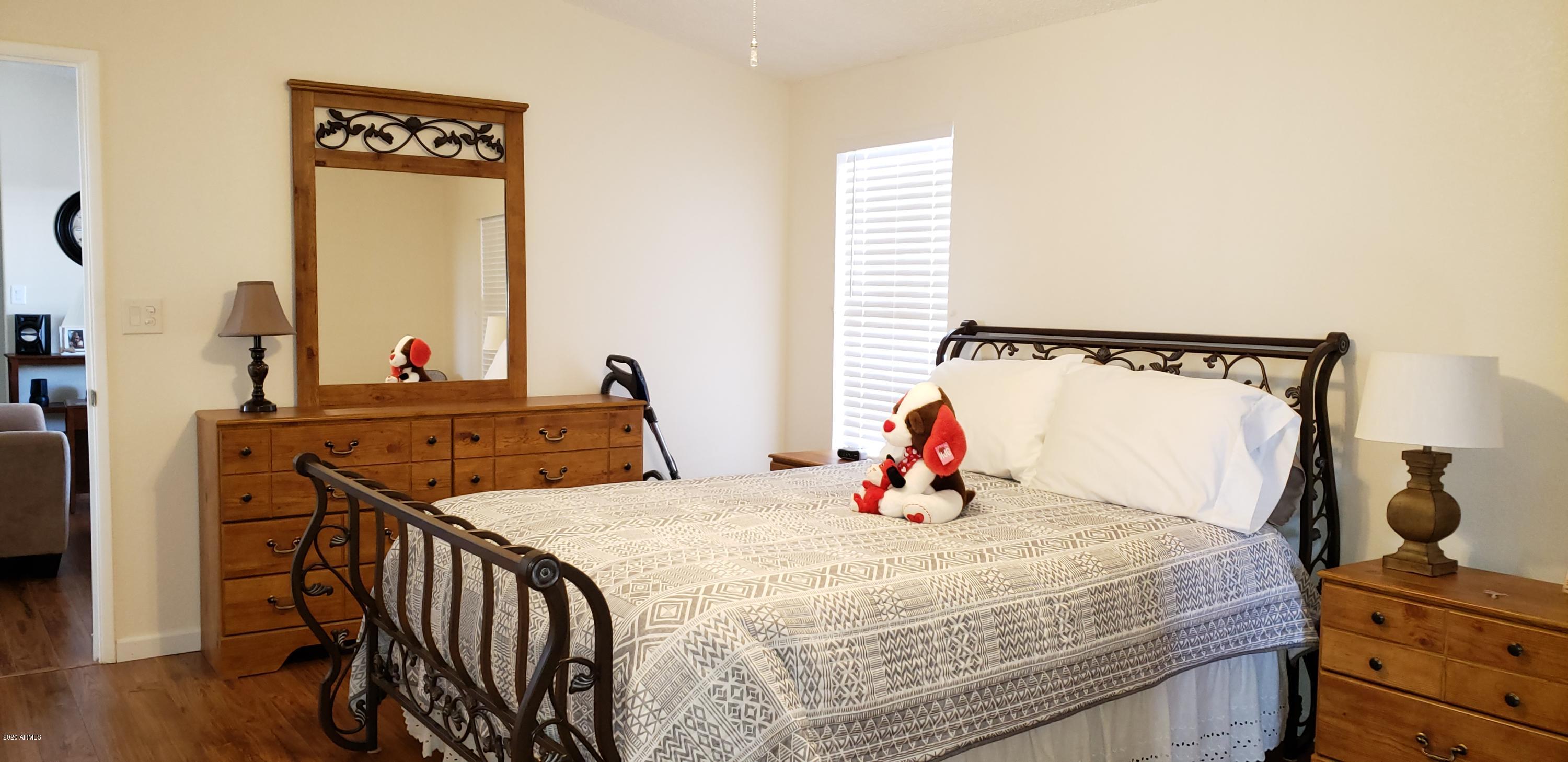 301 South Signal Butte Road, Unit 705 Apache Junction, AZ 85120 - Photo 21 of 50 a bedroom with a bed and wooden floor