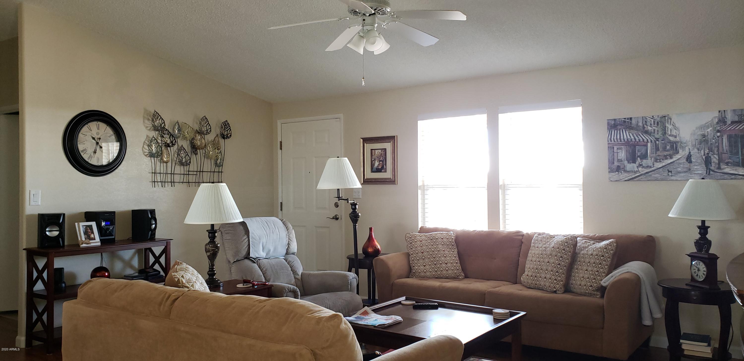 301 South Signal Butte Road, Unit 705 Apache Junction, AZ 85120 - Photo 8 of 50 a living room with furniture a clock and a window