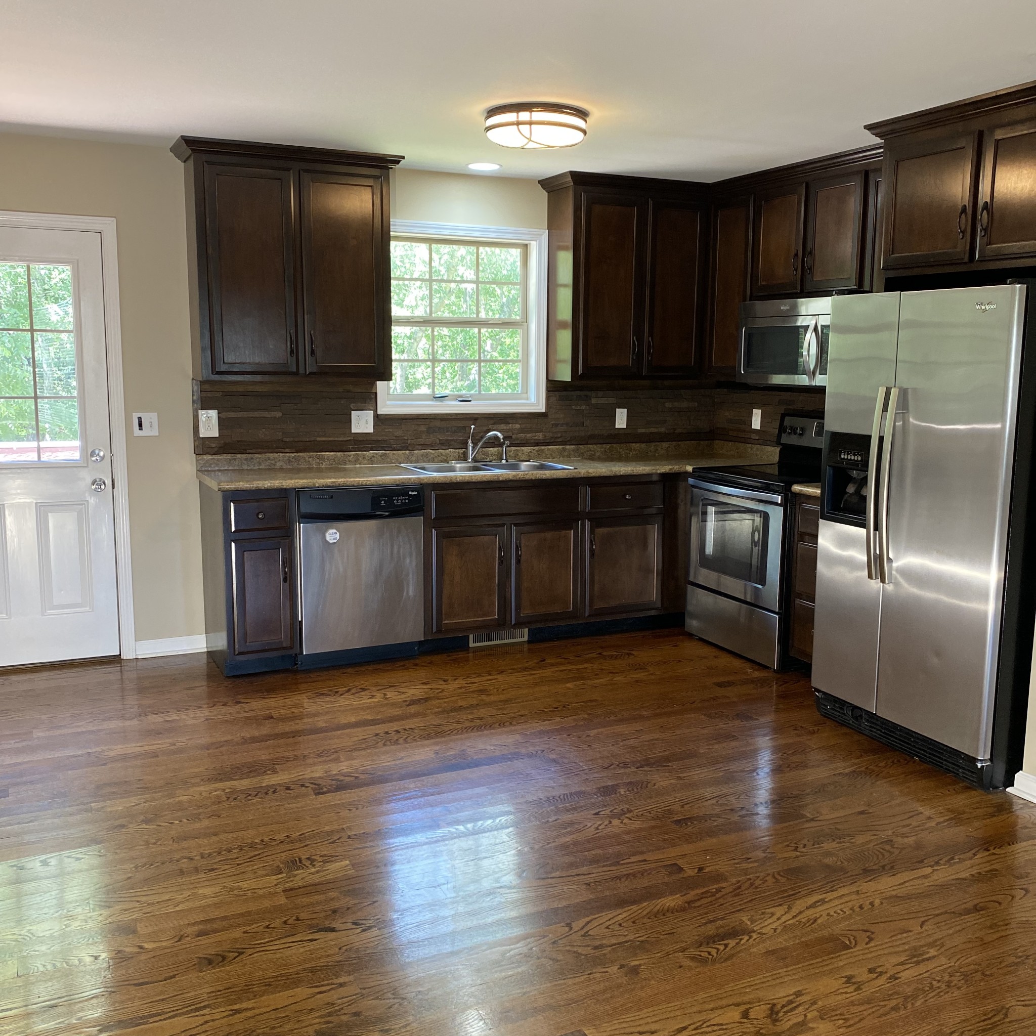 1055 Salem Ridge Road Clarksville, TN 37040 - Photo 10 of 18 a kitchen with granite countertop a stove top oven a sink dishwasher a refrigerator and a microwave oven with wooden floor