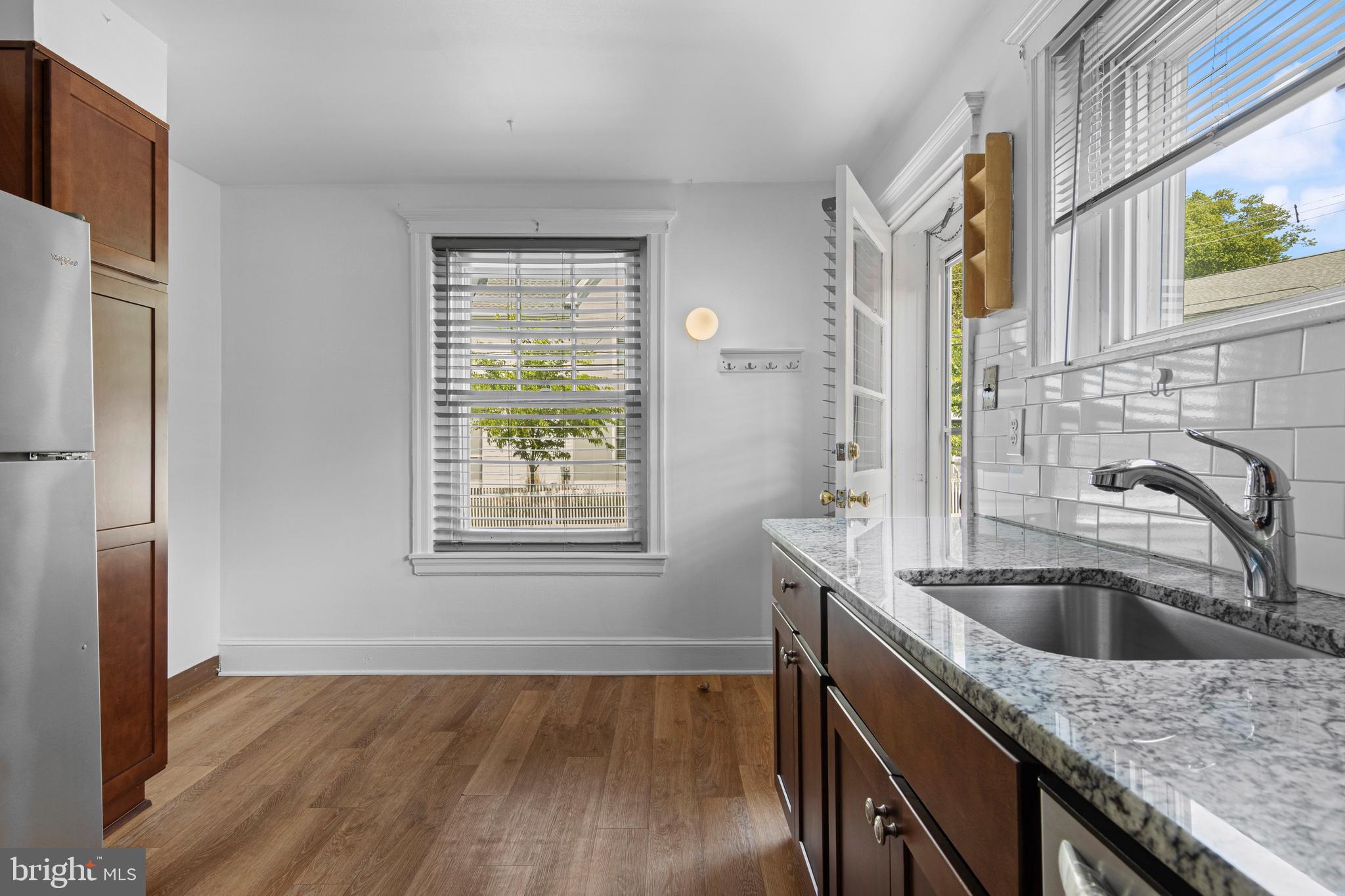 153 Conestoga Road Wayne, PA 19087 - Photo 5 of 13 a kitchen with stainless steel appliances granite countertop a sink a refrigerator and wooden floor