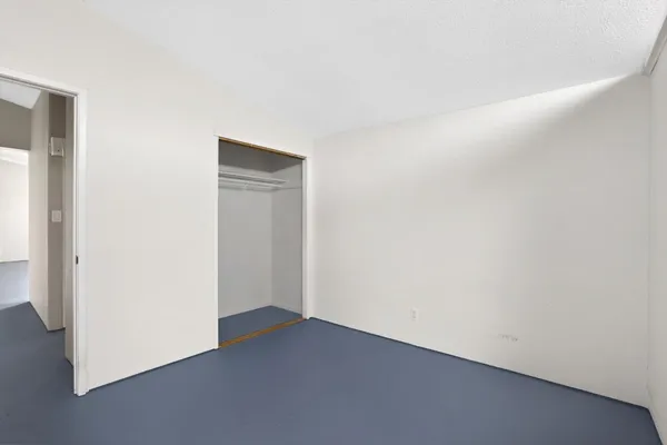 an empty room with wooden floor fireplace and a window