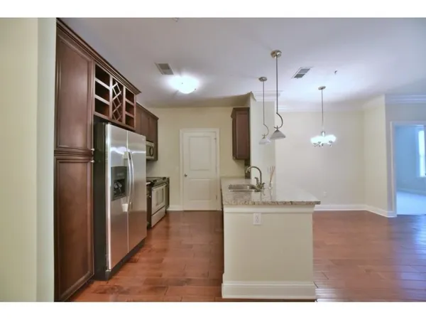 a open kitchen with cabinets stove and a wooden floor