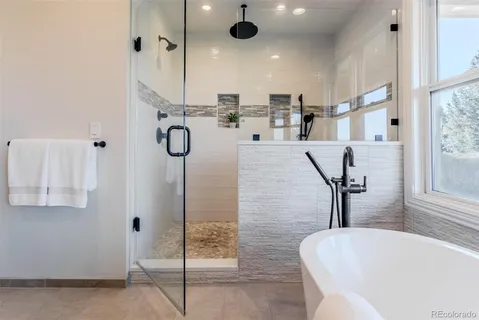 a bathroom with a tub sink and mirror