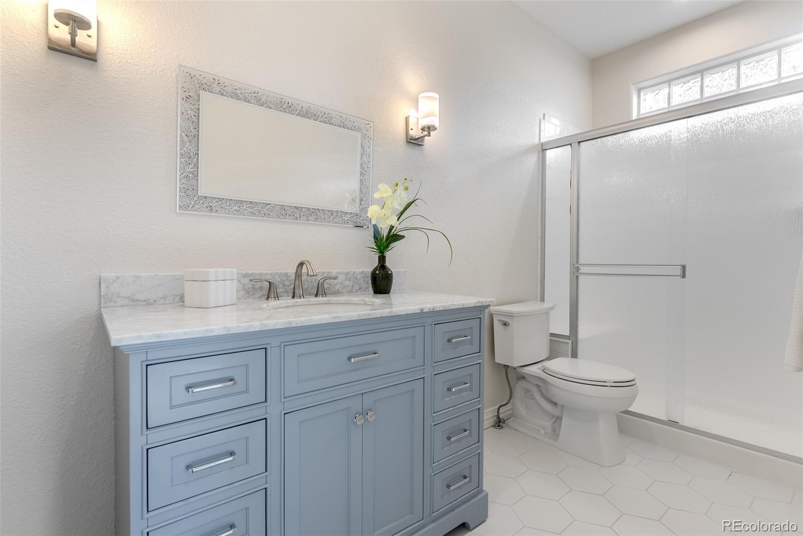 768 Bridger Point Lafayette, CO 80026 - Photo 27 of 50 a bathroom with a granite countertop toilet sink and mirror