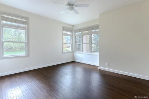 a large white kitchen with granite countertop a sink and cabinets