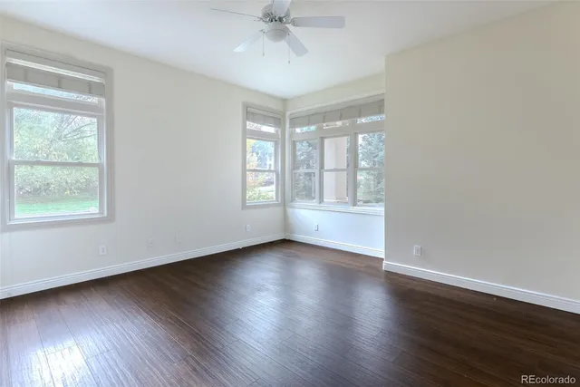 a large white kitchen with granite countertop a sink and cabinets