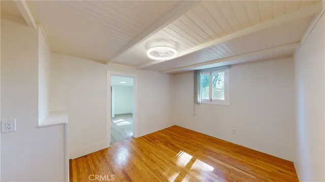 a view of a room with wooden floor and a ceiling fan