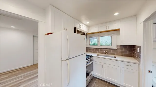 a kitchen with white cabinets and white appliances