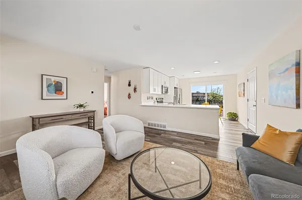 a living room with furniture and a wooden floor