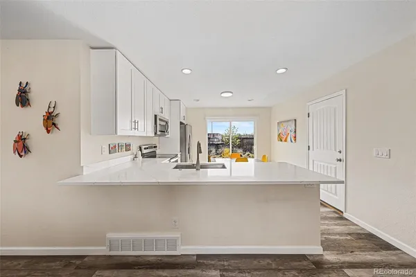 a view of kitchen with stainless steel appliances granite countertop a sink and a counter space