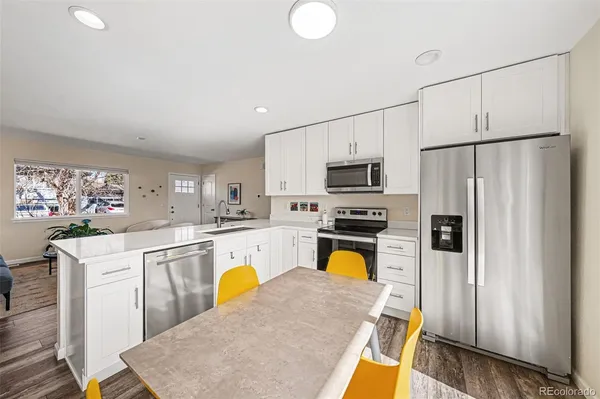 a kitchen with stainless steel appliances a stove refrigerator sink and cabinets