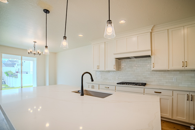 223 South Cottonwood Road, Unit 7501 Vineyard, UT 84059 - Photo 42 of 45 Spacious kitchen featuring a large island with an undermount sink and matte black faucet, white shaker cabinetry, white subway tile backsplash, and a gas range