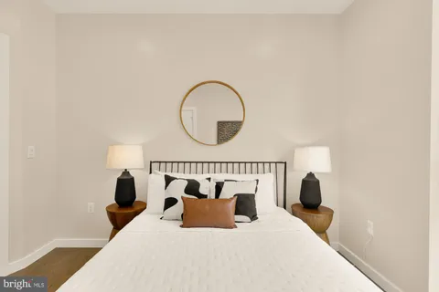 a bed sitting in a bedroom next to a window with a wooden floor