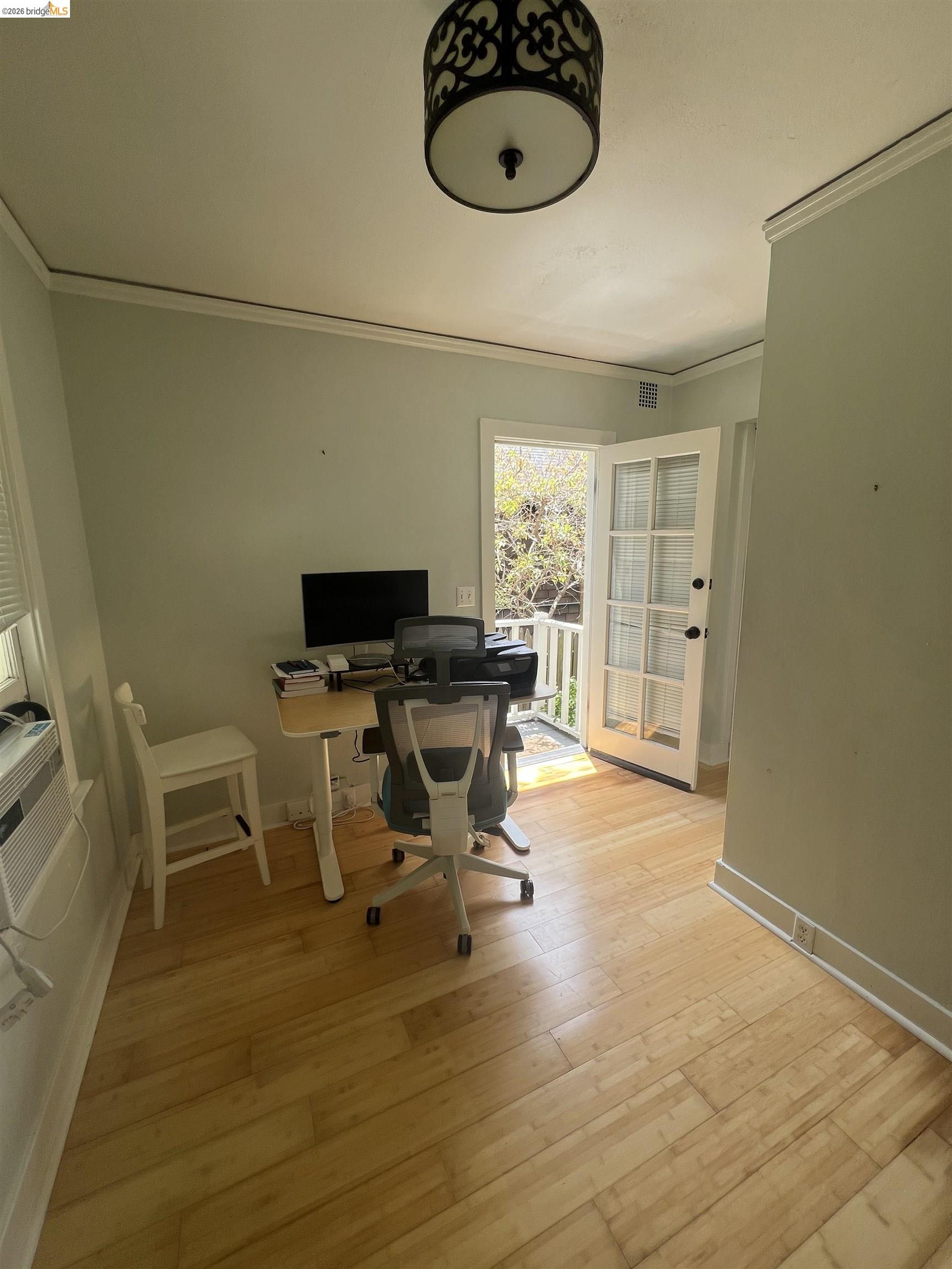 1631 La Vereda Road Berkeley, CA 94709 - Photo 41 of 42 Sunlit room featuring light-toned wood-finish flooring, a decorative semi-flush mount ceiling fixture, and crisp white trim