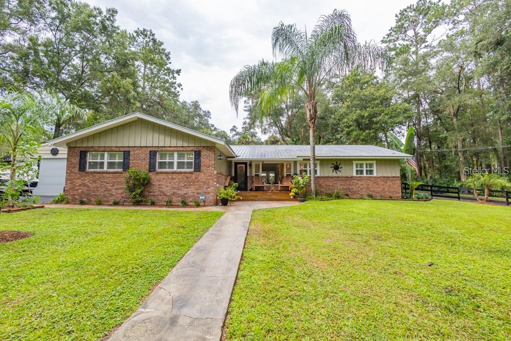 a front view of a house with yard patio and green space
