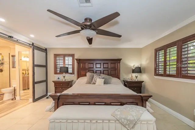 a large bed sitting in a bedroom next to a window